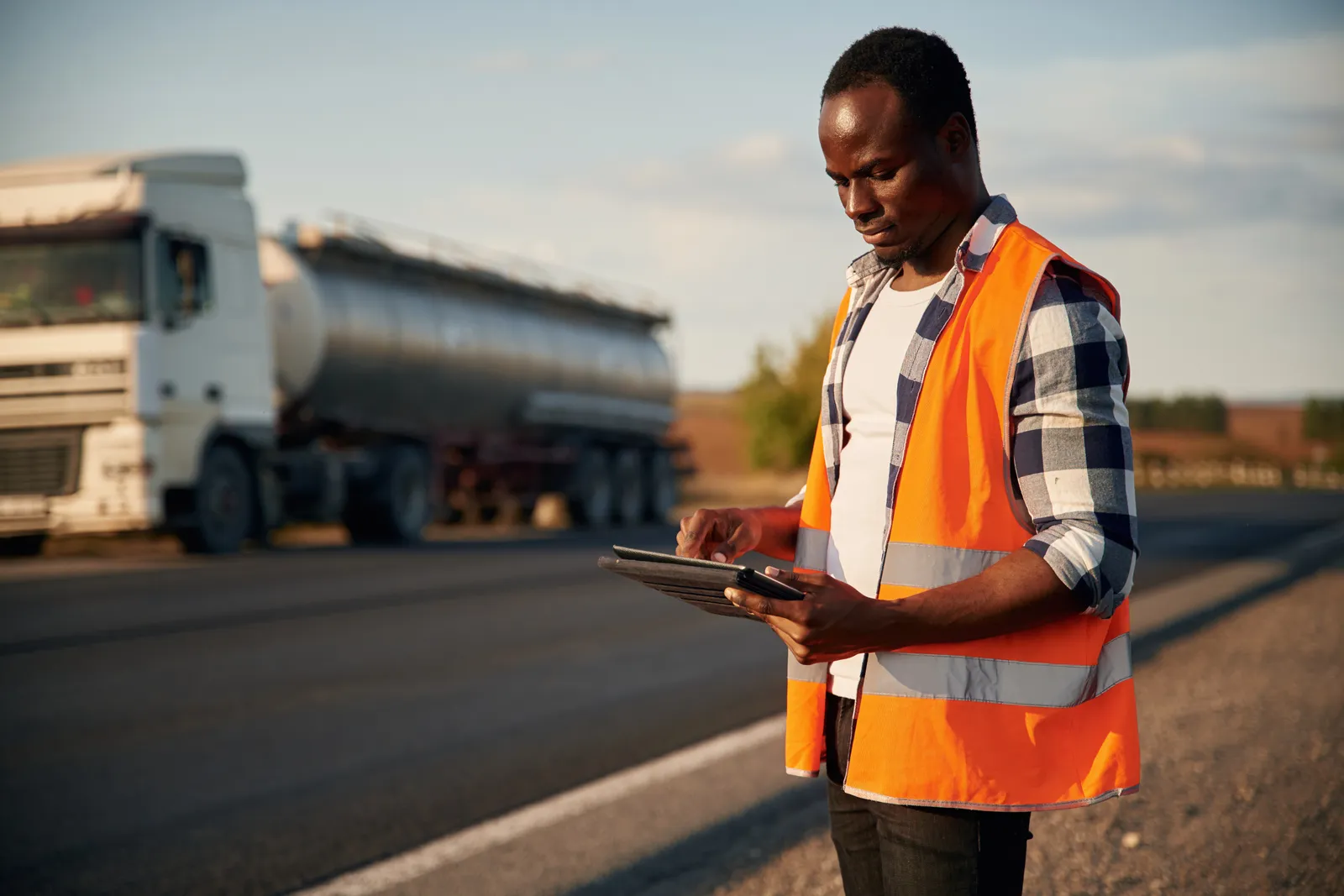 Engineer recording measured quantities on a tablet at a Ghana road chainage