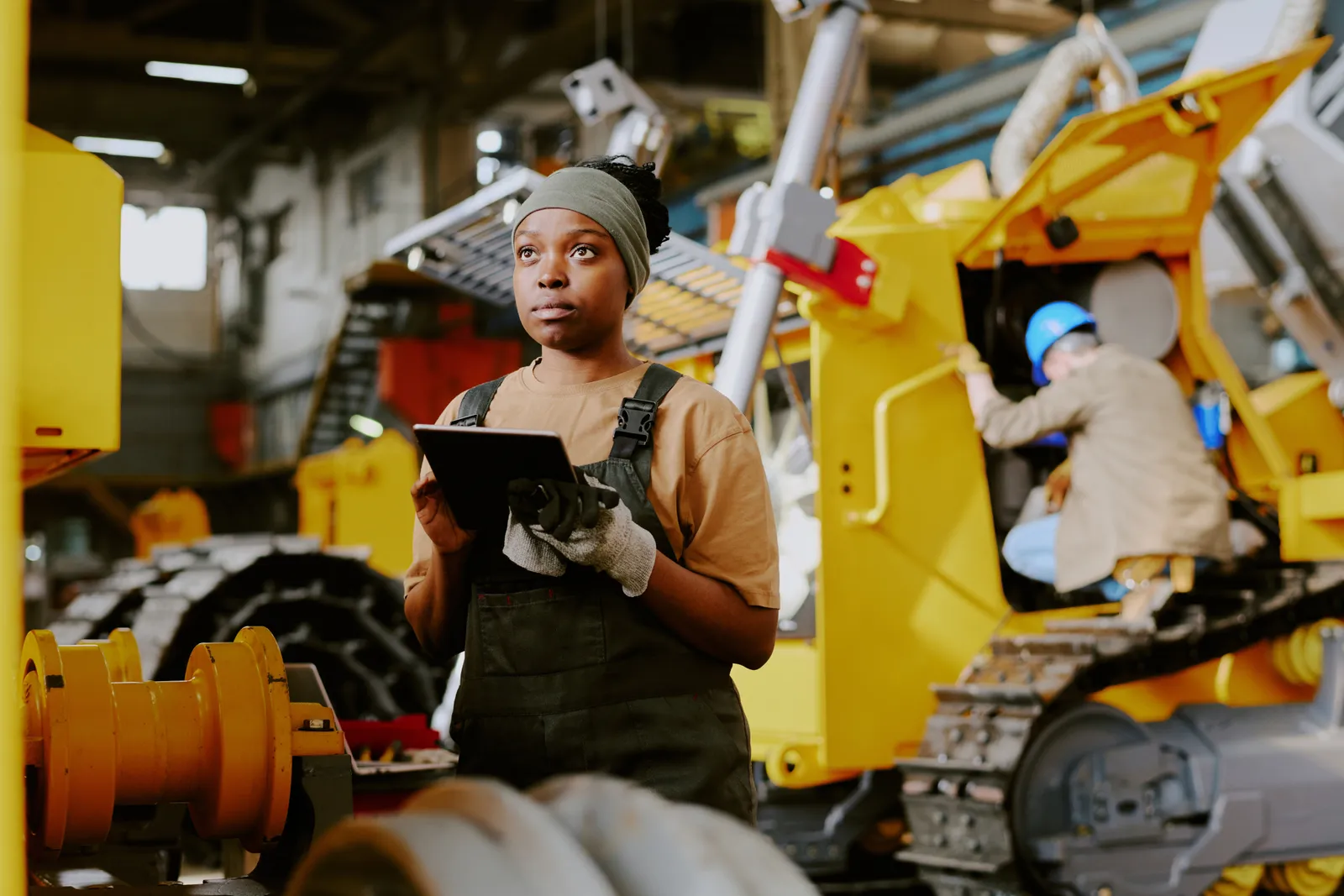 Engineer inspecting heavy plant on a tablet in a Ghana maintenance bay